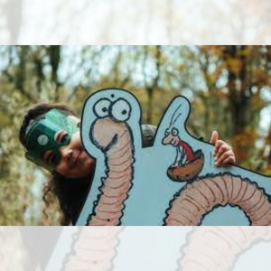 Superworm promotional photo of girl with super worm cutout in forest