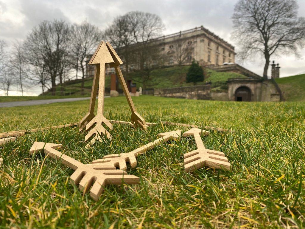 Golden Arrows stacked together pointing to the sky with Nottingham Castle in the background