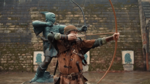 Robin Hood Pulling bow and arrow in front of the Robin hood Statue at Nottingham Castle.