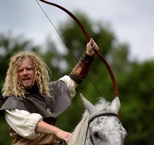 Man on horseback with a bow in hand raised up into the air