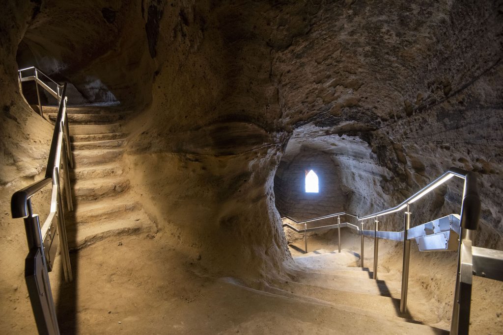 Photo inside Mortimer's hole at Nottingham castle at the corner of the staircase in the cave, with the left set of stairs ascending and the right staircase descending.