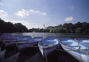 The boating lake at the university of Nottingham with rowing boats in the foreground and the trent building in the background