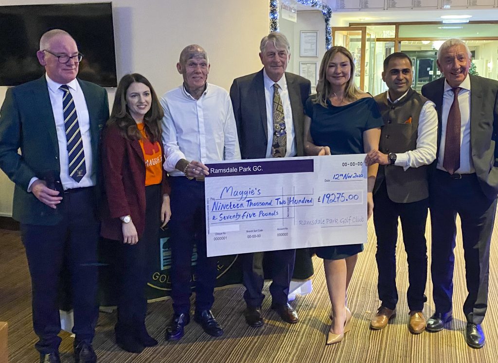 Members of the golf club and charity presenting the cheque on the evening. The cheque is a large novelty cheque.