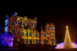 Christmas tree with Wollaton Hall in the background all lit up with Christmas lights