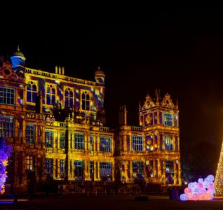 Christmas tree with Wollaton Hall in the background all lit up with Christmas lights