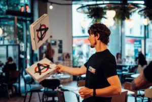 Man throwing some pizza boxes around in Pizza Punks restaurant