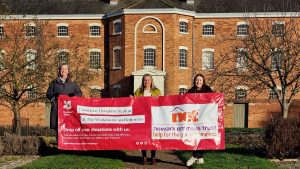 Staff from the workhouse and NET charity with their banner outside the property