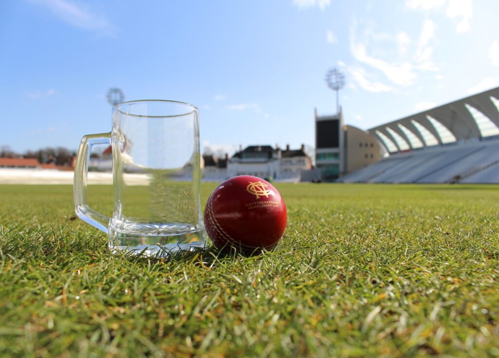 Cricket ball and a beer glass on the grass at trent bridge cricket ground