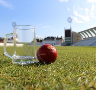 Cricket ball and a beer glass on the grass at trent bridge cricket ground