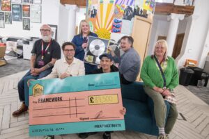 DHP's George Akins holding Beat The Streets cheque with Framework service user Danny