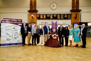 representatives from various councils and bodies all lines up for a photo op at the gates of Nottingham station.