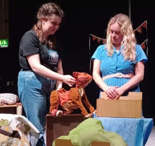 Charlotte and Suzy from Handmade theatre on stage with George the Cat