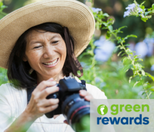 Lady with a big sun hat on, with a DSLR camera smiling