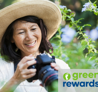 Lady with a big sun hat on, with a DSLR camera smiling