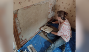 A volunteer carrying out plasterwork at the D.H. Lawrence Birthplace Museum
