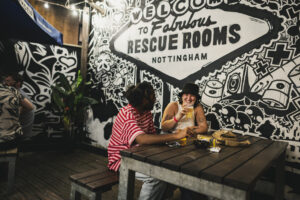 A photo of two people enjoying a drink at DHP's Rescue Rooms venue