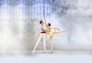 Two ballet dancers in swan lake holding one another.