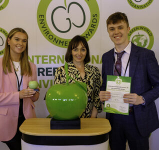 People accepting the green apple award on behalf of EMDO