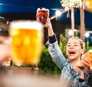 This image shows a girl holding up a beer at FrulingFest at Binks Yard